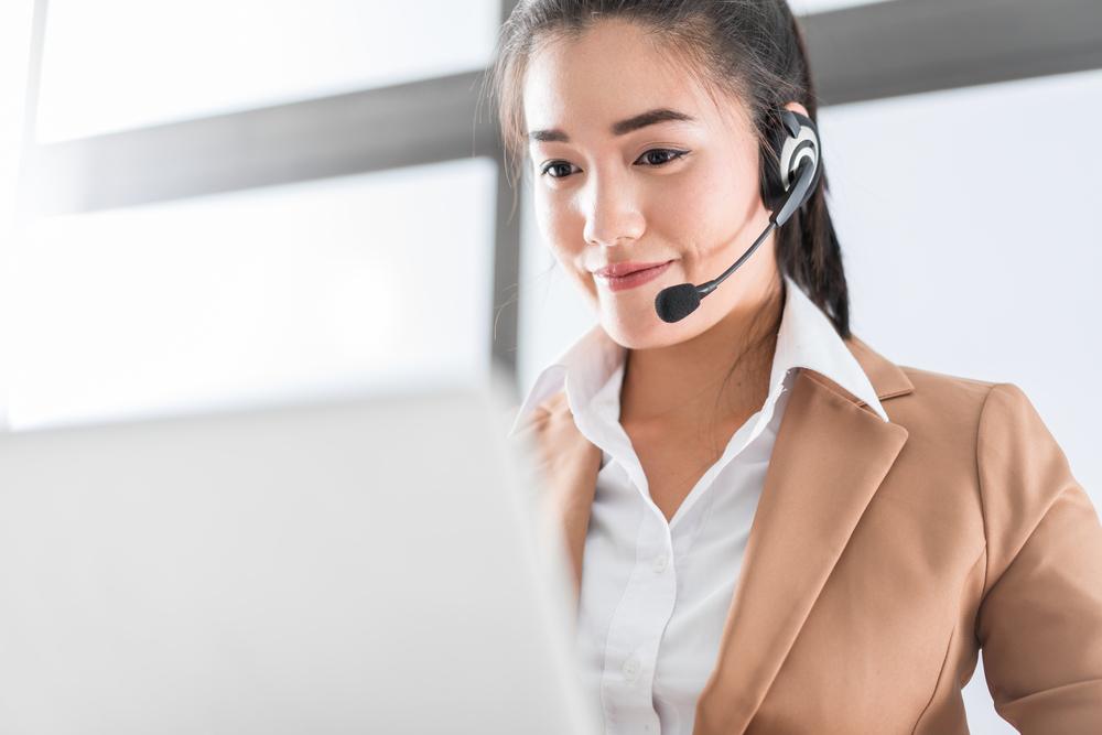 answering service provider with headset working at laptop computer